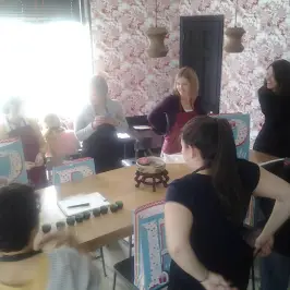 Group of people in a kitchen setting with gift bags and a fondue pot on the table.